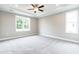 Large primary bedroom features trey ceilings, carpet, and large windows at 169 Tigris Ct, Zebulon, NC 27597