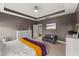 Comfortable main bedroom with tray ceilings, tv, and view to the ensuite bathroom and closet at 1715 Capstone Dr, Durham, NC 27713