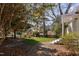 Fenced backyard features lush greenery, a small patio, and mature trees offering shade at 202 High St, Carrboro, NC 27510