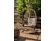 A cozy hanging chair in backyard offers a relaxing spot near fire pit and wooden fence at 202 High St, Carrboro, NC 27510
