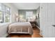 Cozy bedroom with hardwood floors, neutral decor, and natural light streaming through the windows at 202 High St, Carrboro, NC 27510