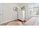 Neat bedroom showcasing hardwood floors, a white dresser, round mirror, and ample natural light at 202 High St, Carrboro, NC 27510