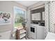 Bright laundry area features new washer and dryer, custom cabinets, and window with view to backyard at 202 High St, Carrboro, NC 27510