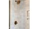 Close-up of a shower showcasing decorative white tiles, gold hardware, and a built-in niche at 202 High St, Carrboro, NC 27510
