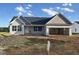 Charming single-Gathering home featuring a spacious two-car garage and stylish gray siding, set under a bright blue sky at 207 N Movado Trl, Kenly, NC 27542
