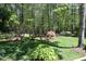 A large backyard with trees, grass, and landscaping offering a private outdoor space at 21 Wedgewood Rd, Chapel Hill, NC 27514