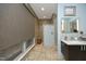 Spa-like bathroom with a stone tiled shower, modern vanity and large window at 21 Wedgewood Rd, Chapel Hill, NC 27514