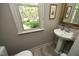 Charming bathroom with pedestal sink and a window view of the lush outdoor landscape at 21 Wedgewood Rd, Chapel Hill, NC 27514