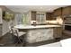 An open concept kitchen features an island with seating, wooden cabinets, and a window for natural light at 21 Wedgewood Rd, Chapel Hill, NC 27514