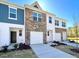 Inviting townhome exterior featuring brick and blue siding, garage and well maintained lawn at 2121 Trailside Dr, Durham, NC 27704