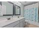 Bathroom with double sink vanity, modern fixtures, and shower with blue floral curtain at 2220 Rainy Lake St, Wake Forest, NC 27587