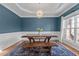 Dining room featuring blue accent wall, modern chandelier and a large wooden table at 2220 Rainy Lake St, Wake Forest, NC 27587