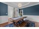 Bright dining room featuring blue accent wall, modern chandelier and a large wooden table at 2220 Rainy Lake St, Wake Forest, NC 27587