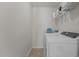 White laundry room with washer, dryer, tile flooring, and storage shelves at 2220 Rainy Lake St, Wake Forest, NC 27587