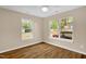 Bedroom with neutral walls, hardwood floors, and natural light from two windows at 230 N Melville St, Graham, NC 27253
