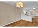 Bright dining area features a modern chandelier and hardwood floors connecting to the open kitchen at 230 N Melville St, Graham, NC 27253
