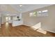 Bright living room with modern flooring, neutral walls, vaulted ceiling and ample natural light from large windows at 230 N Melville St, Graham, NC 27253