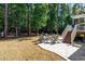 Beautiful backyard setting with stone patio, fire pit, and mature trees at 2739 Elderberry Ln, Apex, NC 27539