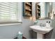 Charming powder room with pedestal sink, built-in shelving, and neutral gray walls at 2739 Elderberry Ln, Apex, NC 27539