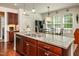 Kitchen island featuring granite counters, stainless steel sink and wood cabinets at 2739 Elderberry Ln, Apex, NC 27539