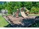 Community playground featuring slides, climbing structure and benches, all surrounded by lush trees for shade at 2739 Elderberry Ln, Apex, NC 27539