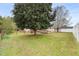 Wide shot of backyard featuring a large tree, a deck, and a fenced-in area at 2782 N Shiloh Rd, Garner, NC 27529