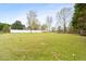 Expansive backyard featuring a large grassy area, surrounded by a white fence and mature trees at 2782 N Shiloh Rd, Garner, NC 27529