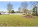 View of the spacious backyard with a white fence, shed and some piled leaves in the corner at 2782 N Shiloh Rd, Garner, NC 27529