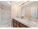 Bathroom with a double sink vanity, a large mirror, and a shower-tub combo at 2782 N Shiloh Rd, Garner, NC 27529