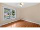 Bright room featuring wood-look floors, a ceiling fan, and a window offering a view of the porch at 2782 N Shiloh Rd, Garner, NC 27529