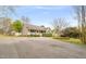 View of the home with a long driveway, American flag on the porch and mature trees at 2782 N Shiloh Rd, Garner, NC 27529