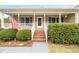Inviting front porch with brick steps, white railing, and an American flag display at 2782 N Shiloh Rd, Garner, NC 27529