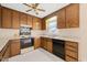 Well-lit kitchen featuring wood cabinetry, laminate countertops, and vinyl flooring at 2782 N Shiloh Rd, Garner, NC 27529