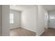 Spacious room with wood-look floors and light walls, featuring a window and doorway leading to another room at 291 Hanging Elm Ln, Fuquay Varina, NC 27526
