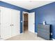 Bedroom features neutral carpeting, a dark blue accent wall, and ample storage at 3059 Hyco Lake Ct, Fuquay Varina, NC 27526