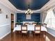 Elegant dining room with a unique blue ceiling, a modern chandelier, and a large table for entertaining at 3059 Hyco Lake Ct, Fuquay Varina, NC 27526