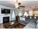 Cozy living room with a fireplace, ceiling fan, and a view into the kitchen and dining area at 3059 Hyco Lake Ct, Fuquay Varina, NC 27526