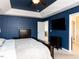This main bedroom has a tray ceiling, neutral carpet, and a blue accent wall at 3059 Hyco Lake Ct, Fuquay Varina, NC 27526