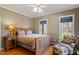 Serene bedroom featuring warm lighting, a comfortable chair, and large windows at 3120 A Timberlyne Dr, Mebane, NC 27302
