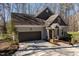 Home exterior featuring an attached garage, professional landscaping, and covered front porch at 3120 A Timberlyne Dr, Mebane, NC 27302
