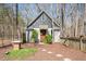 Charming outbuilding with a red door and surrounding lush landscaping and privacy fence at 3120 A Timberlyne Dr, Mebane, NC 27302