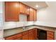 Home wet bar with granite countertops, wooden cabinets, and stainless steel sink at 3120 A Timberlyne Dr, Mebane, NC 27302