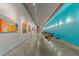 Long gallery hallway features concrete floors, track lighting, and colorful artwork at 319 Fayetteville St # 207, Raleigh, NC 27601