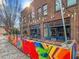 Exterior view of a vibrant storefront with colorful mural and outdoor seating, a place for community engagement at 319 Fayetteville St # 207, Raleigh, NC 27601