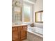 Bright bathroom showcases a soaking tub with tile surround and frosted glass window at 4 Teahouse Ct, Durham, NC 27707
