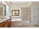 Well-lit bathroom features a glass shower, soaking tub, and double vanity at 4 Teahouse Ct, Durham, NC 27707