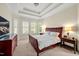 Spacious bedroom with tray ceiling, large windows, and carpeted floors for a cozy retreat at 4 Teahouse Ct, Durham, NC 27707