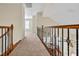 Second story hallway with carpet, wood railing, and black iron spindles at 4 Teahouse Ct, Durham, NC 27707