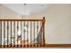 View from second story landing of curved staircase with chandelier and hardwood floors at 4 Teahouse Ct, Durham, NC 27707