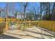 View of the wooden back deck with railing, overlooking a lush and fenced-in backyard at 4532 Draper Rd, Raleigh, NC 27616